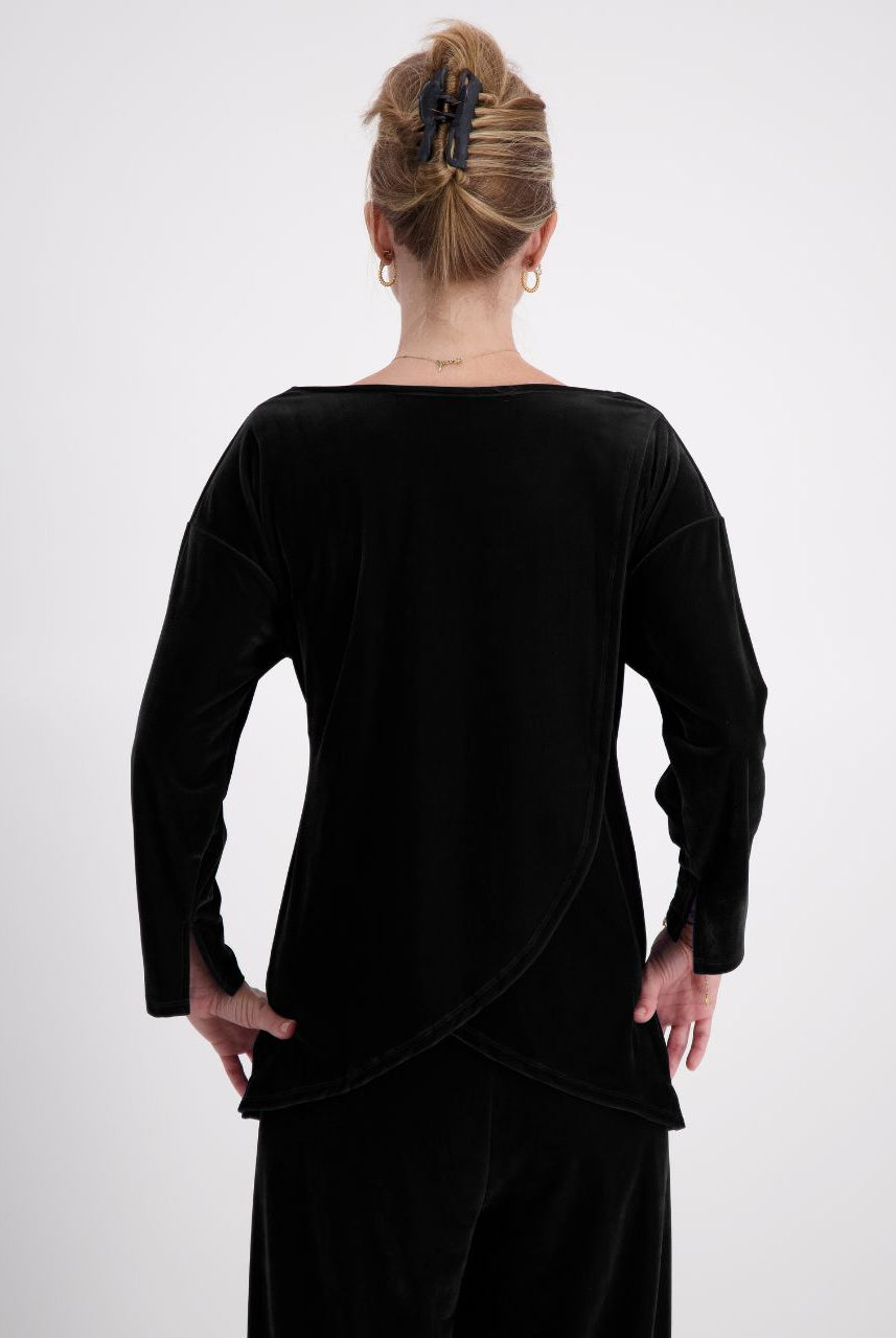 Emma Boat Neck Leaf Back Top shown from behind, featuring luxurious black velvet fabric with distinctive overlapping leaf design at back. Three-quarter length sleeves with split cuffs, showcasing elegant draping and sophisticated tailoring against neutral background.