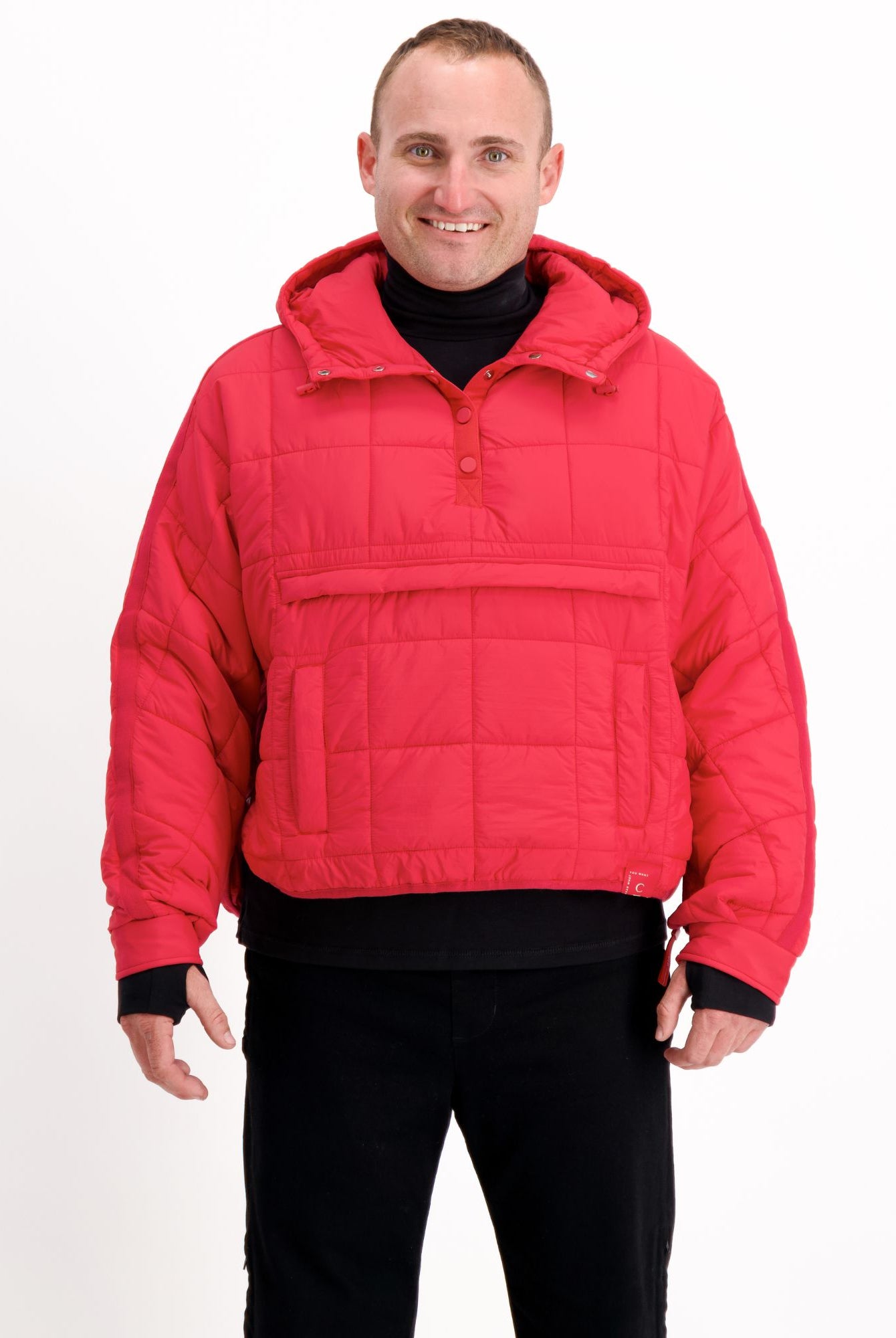 The Elly Universal Puffer Jacket in vibrant red features a pullover design with front kangaroo pocket, hood, and quilted pattern. The adaptive jacket has a relaxed fit with ribbed cuffs, shown against white background, demonstrating its practical and stylish design for wheelchair users.