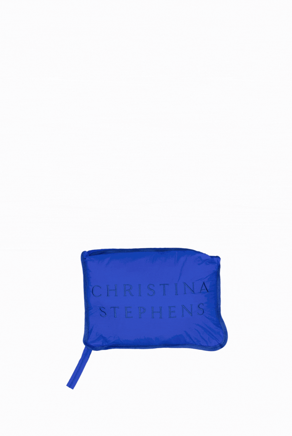 Matt Gender Neutral Puffer Vest shown folded into its compact travel pillow form, displaying a vibrant royal blue color with embossed branding on the surface, featuring a small zipper detail for easy conversion.