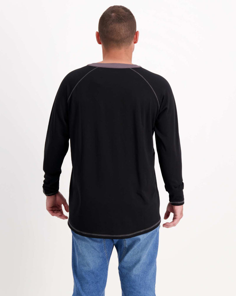 Standing male is wearing a bamboo long sleeve raglan style t-shirt with jeans. Christina Stephens Adaptive Clothing Australia.
