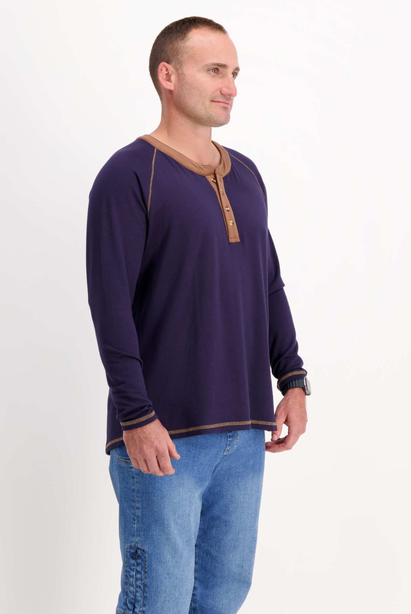 Sir Lord Raglan T-Shirt shown in navy blue with contrasting brown henley collar and trim, styled with blue jeans against white background, displaying classic A-line silhouette and long sleeve design