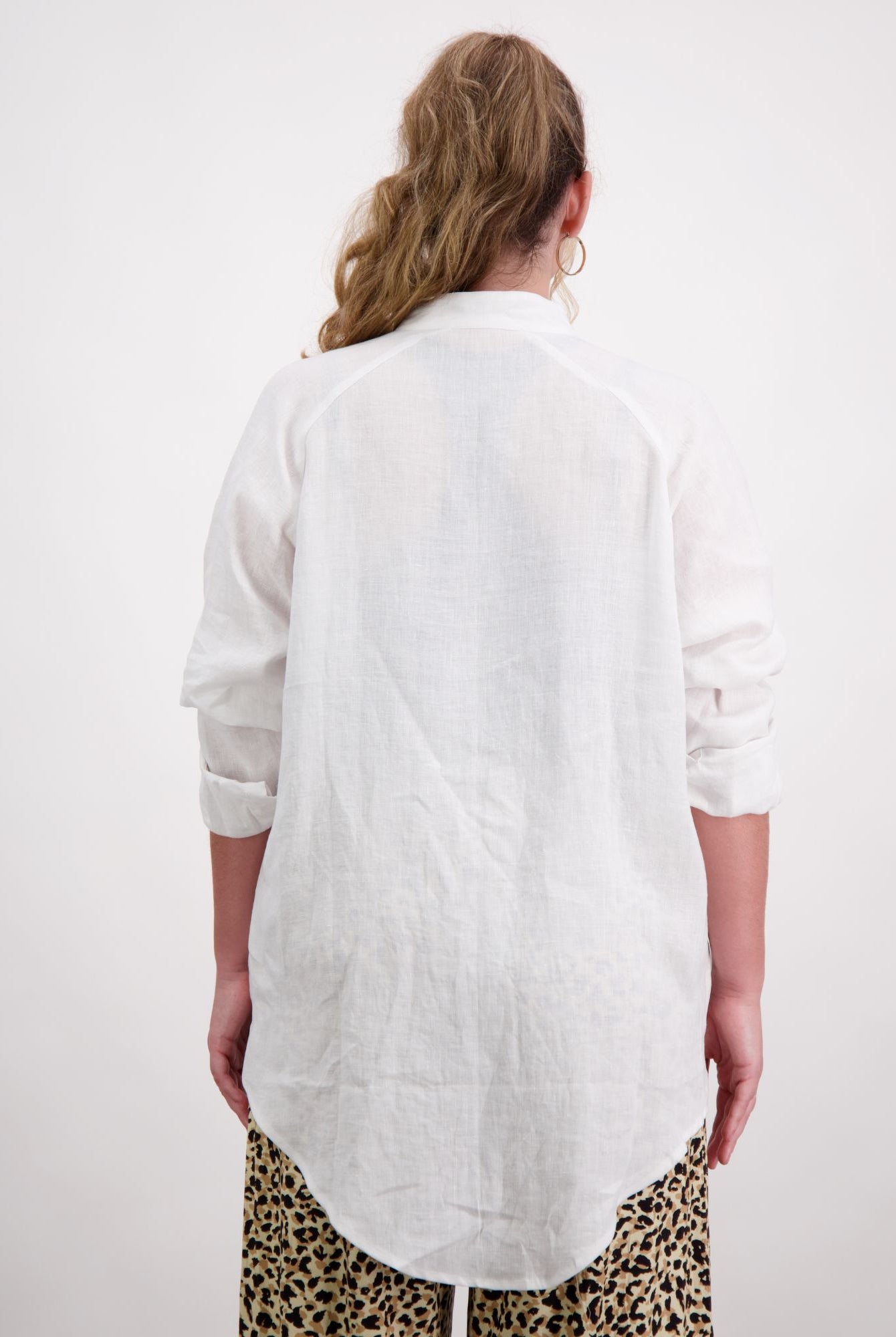 Standing female wearing a grandfather collar white linen shirt. Christina Stephens Adaptive Clothing Australia.