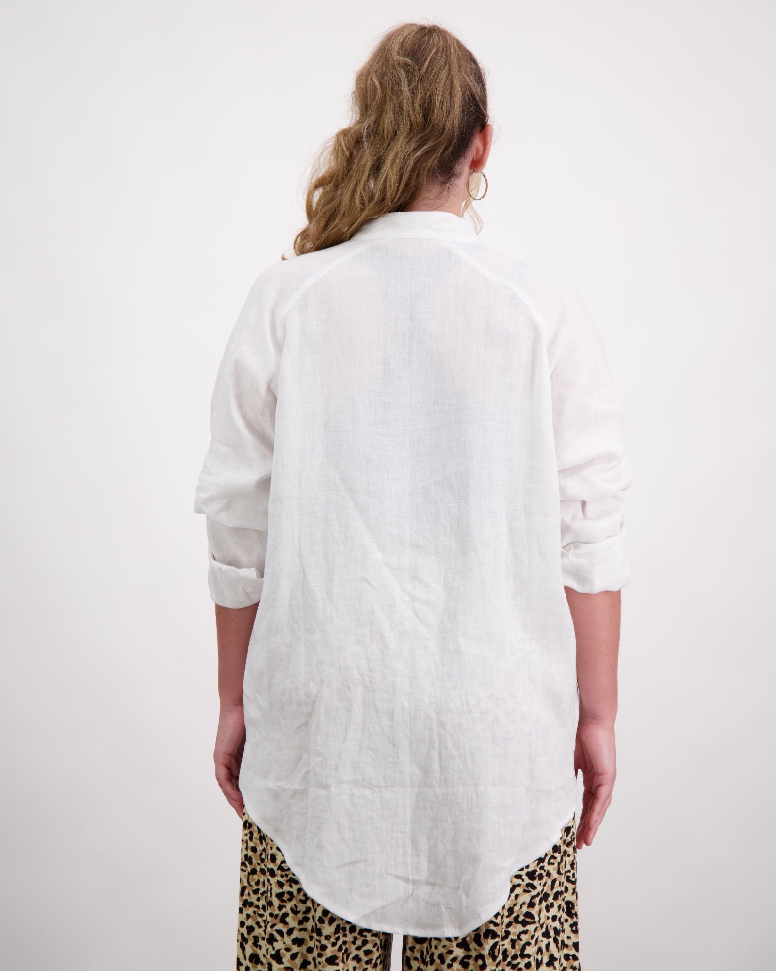 Standing female wearing a grandfather collar white linen shirt. Christina Stephens Adaptive Clothing Australia.