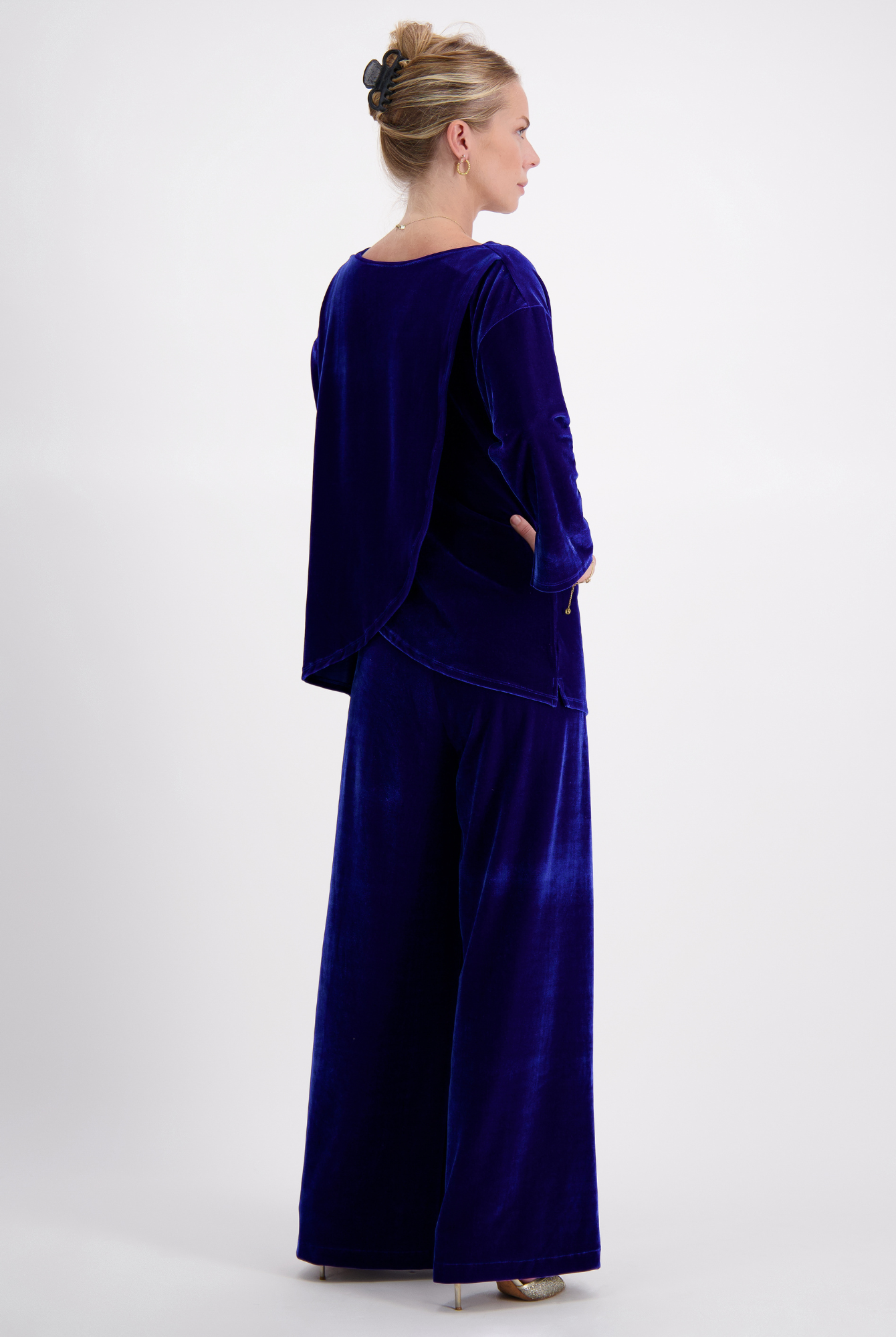 Jessie Wide Leg Velvet Pants shown in royal blue velvet from back view, paired with matching long-sleeve top, showcasing elegant flow and luxurious texture against white background. Side pockets visible, demonstrating practical design element.