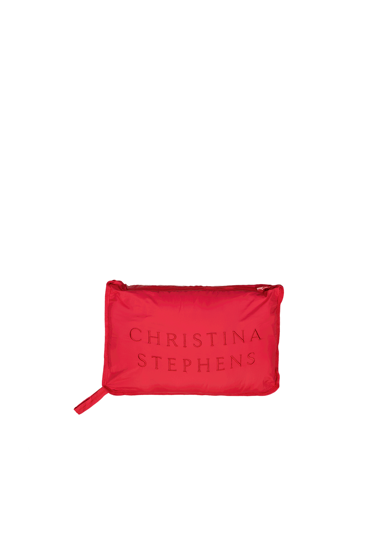 Elly Universal Puffer Jacket shown folded into its compact travel pillow form, displaying a vibrant red color with embossed text on the surface. The rectangular pillow features clean lines and a zip closure, demonstrating the jacket's innovative convertible design.