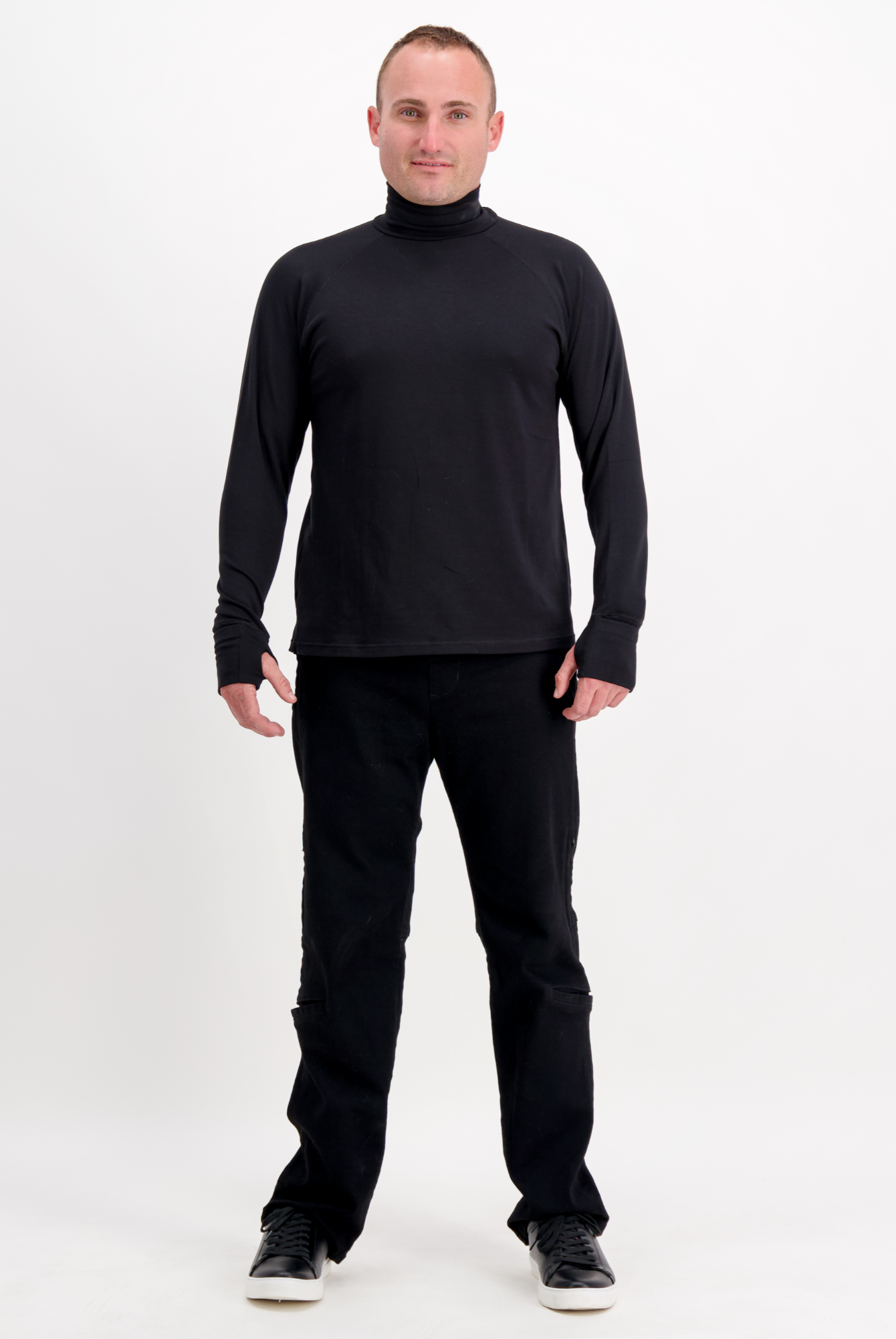 Louis Thermal Top shown in classic black, featuring a sleek turtleneck design and long sleeves. Full-length view displays the versatile fit paired with matching black pants and casual footwear against a white background.