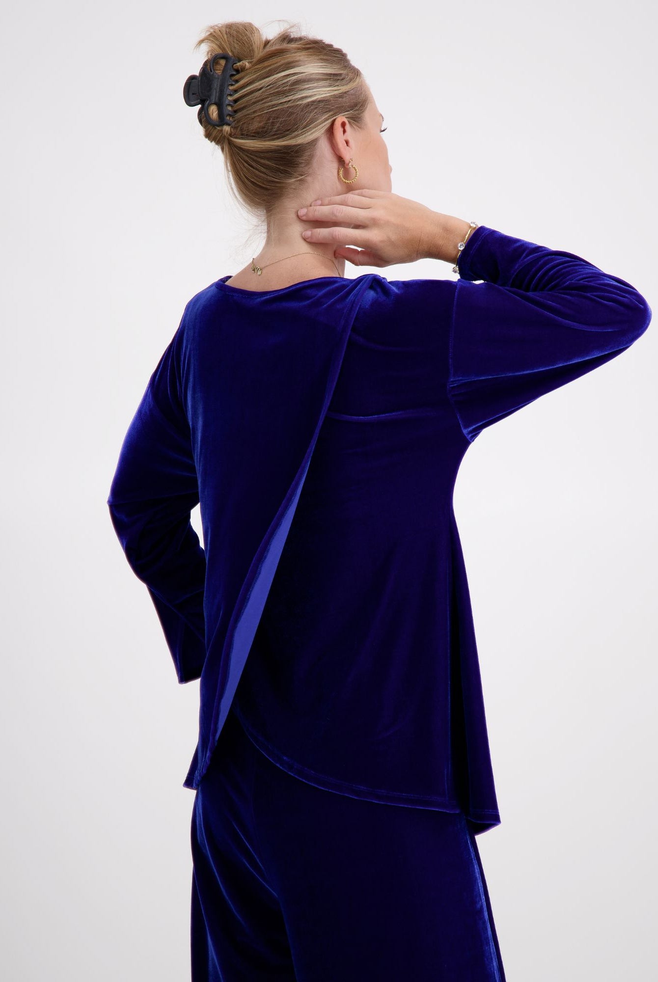 Emma Boat Neck Leaf Back Top shown from behind in luxurious cobalt blue velvet, featuring unique leaf-shaped back design, 3/4 length sleeves with split cuffs, and elegant boat neckline. The plush fabric catches light beautifully, displaying the rich texture of the velvet material.