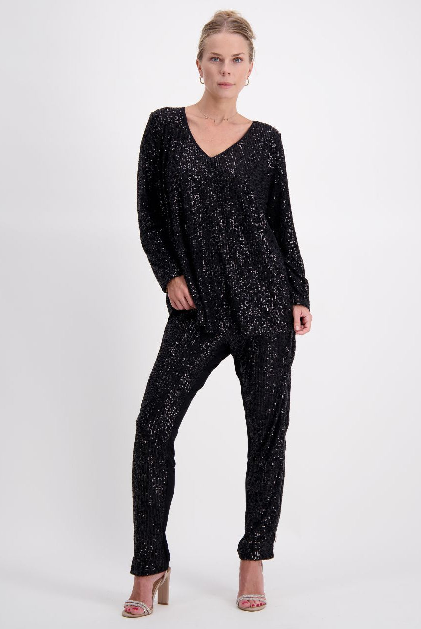 Tara V Neck Leaf Back Top shown in black metallic glitter fabric with full-length sleeves and V-neckline, styled as a complete outfit with matching sequined pants and neutral heels against a white background