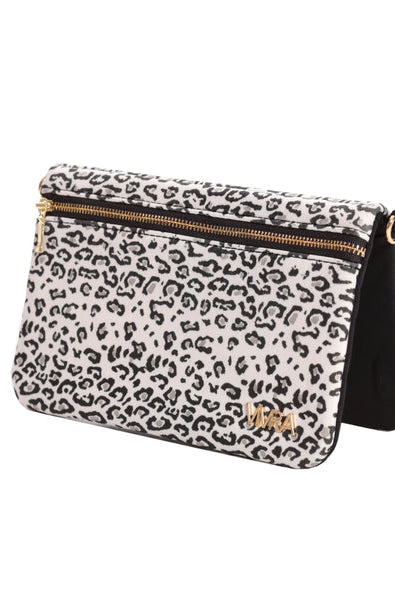 The VIVRA 'Chic' waist bag with a black and white leopard print pattern and gold zipper detailing, featuring a brand emblem in gold that says, 'Vivra', angled upright against a white backdrop.