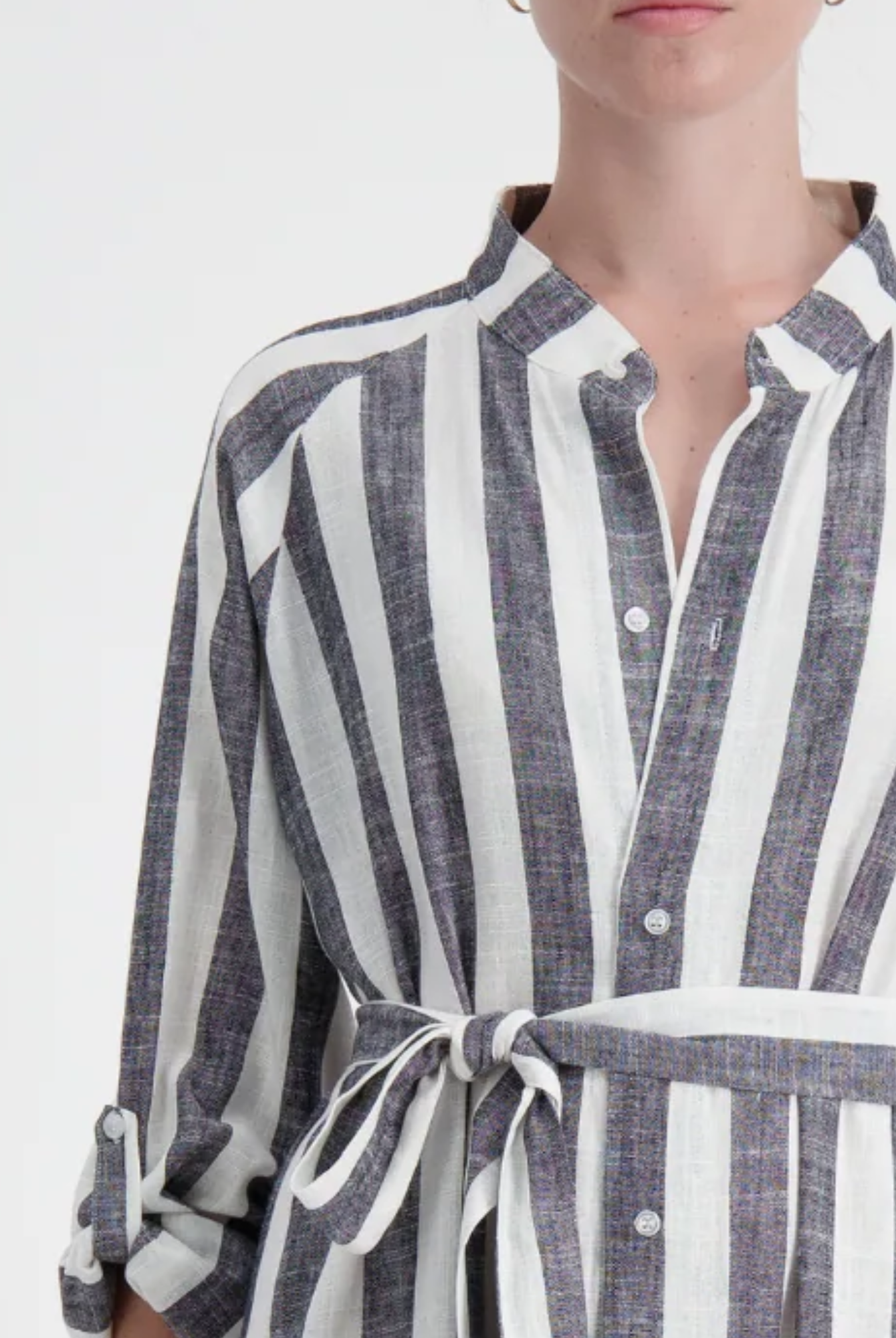 Sapphire Magnetic Shirt Dress in elegant gray and white vertical stripes, featuring a collared neckline, magnetic closures, and a waist-defining belt tie. Close-up view shows the linen fabric texture and relaxed fit of this easy-dressing essential.