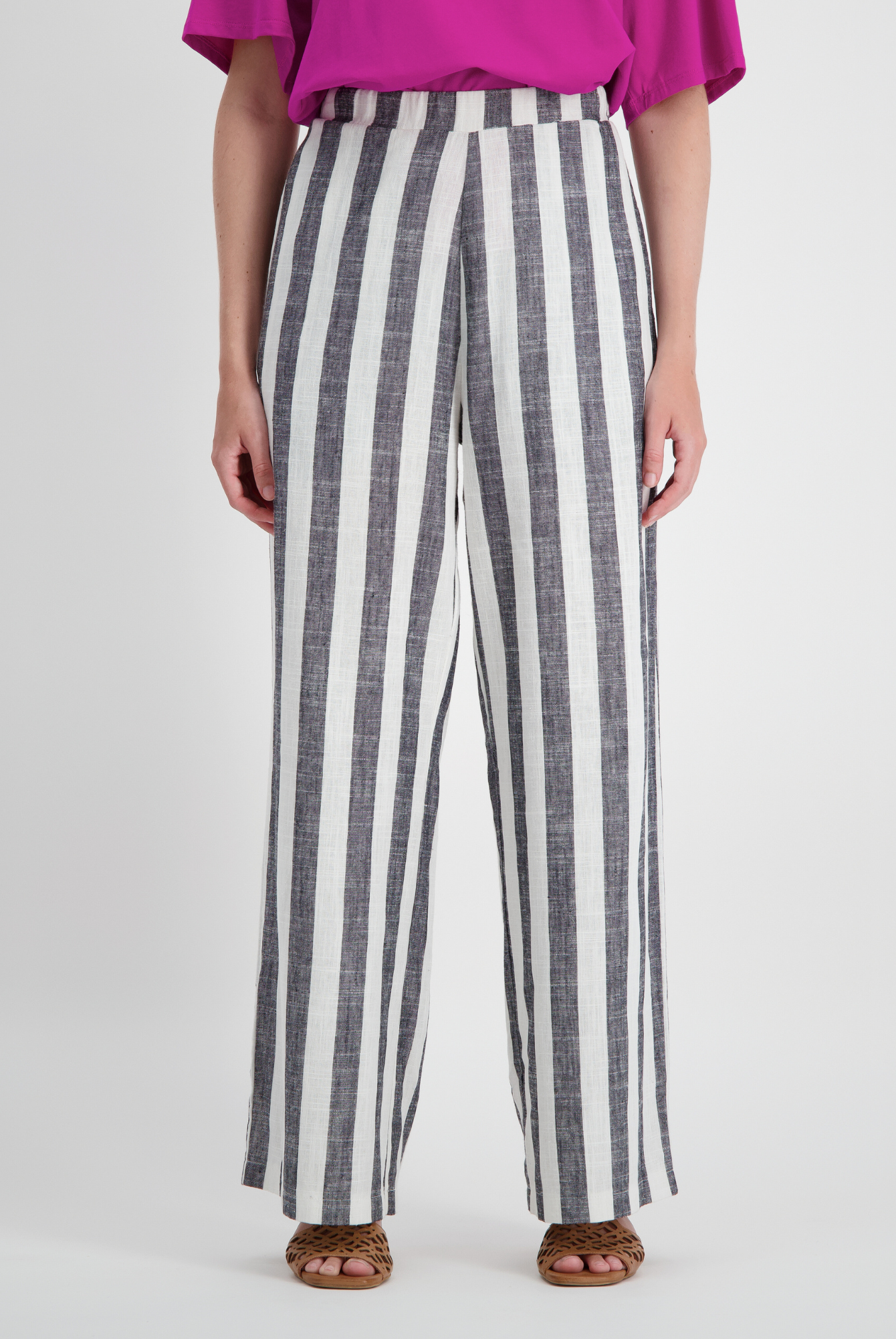 Jessie Wide Leg Pant featuring bold black and white vertical stripes in bamboo and linen blend fabric, styled with a flowing wide-leg silhouette and paired with a vibrant fuchsia top and brown sandals, showcasing adaptive comfort and elegant design