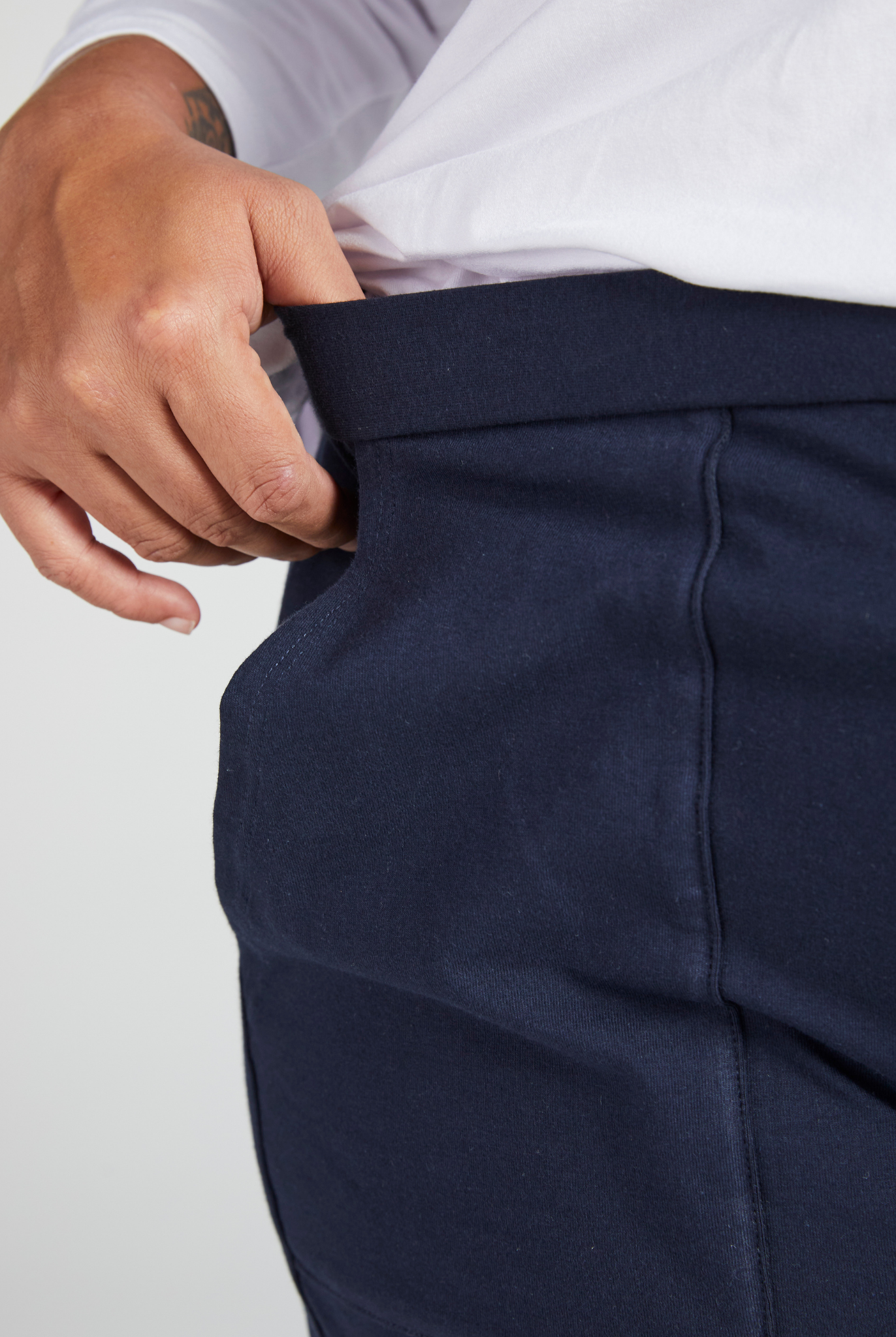 Close-up view of Tapered Track Pants with Hidden Pouch showing navy blue fabric with concealed inner pocket detail, demonstrating the discreet storage feature against a white background