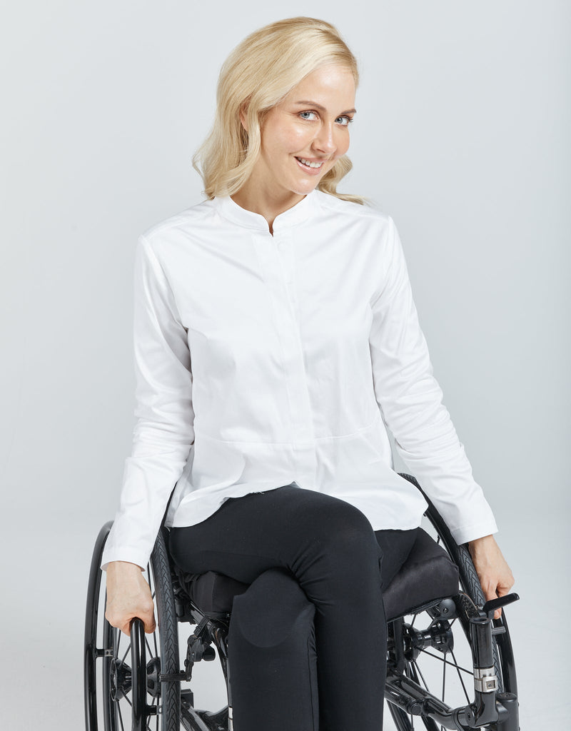 Image of a blonde female in a wheelchair wearing a white Chinese collared shirt with black leggings. Christina Stephens Adaptive Clothing Australia. 
