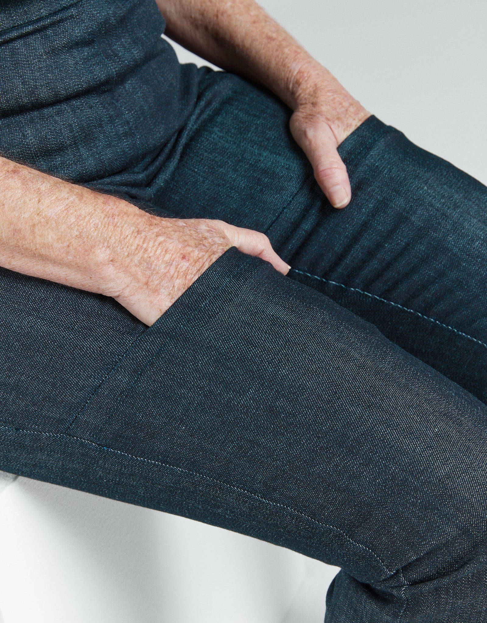 Close-up of hands in pockets wearing Women's Seated Stretch Pant - Indigo dark blue soft elastic trousers.