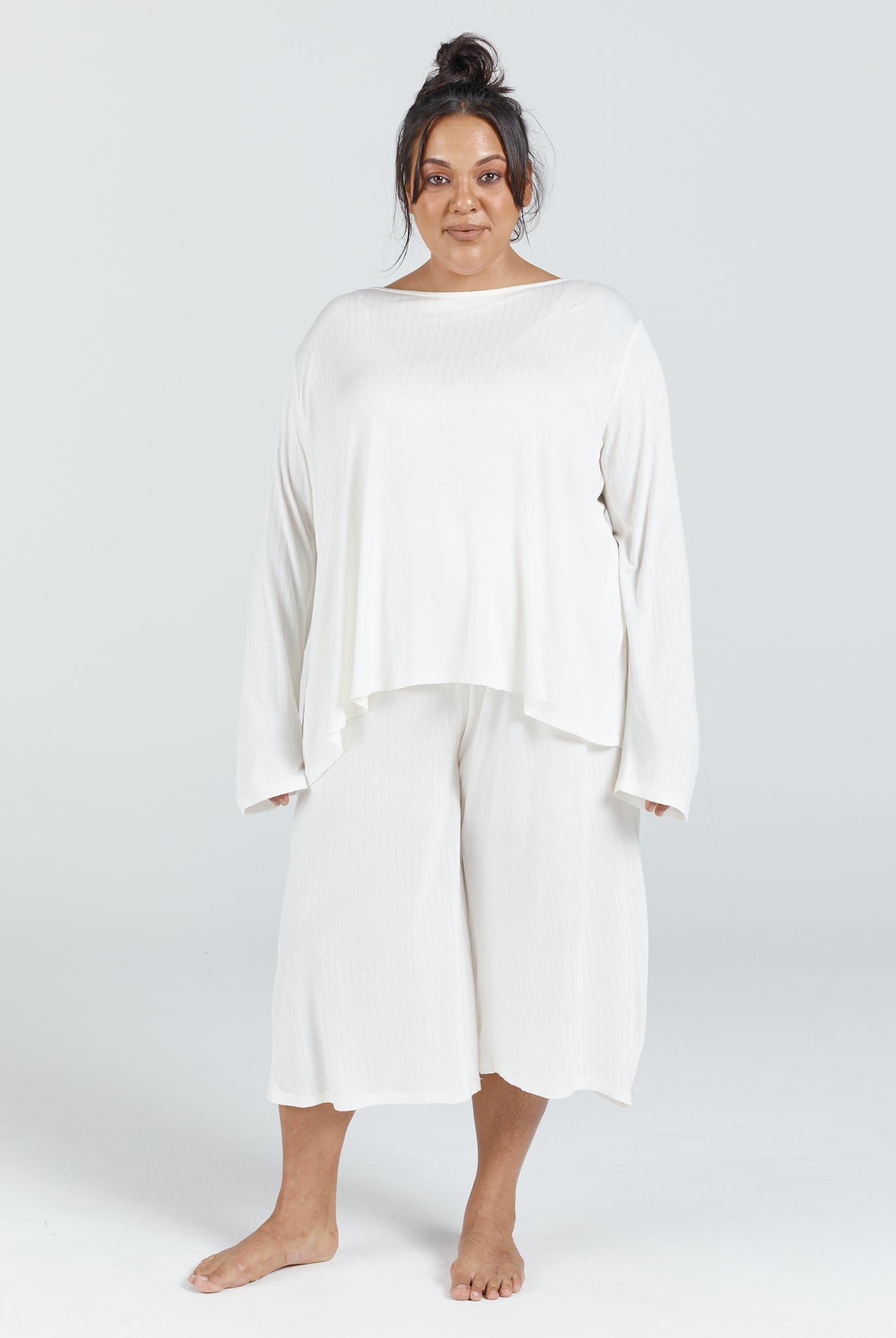 Essensual PJ Pant showcased in soft white, featuring a relaxed-fit culotte style with comfortable elastic waistband, paired with a flowing long-sleeve top. The sleepwear set offers modern sophistication in a lightweight, breathable fabric against a neutral background.