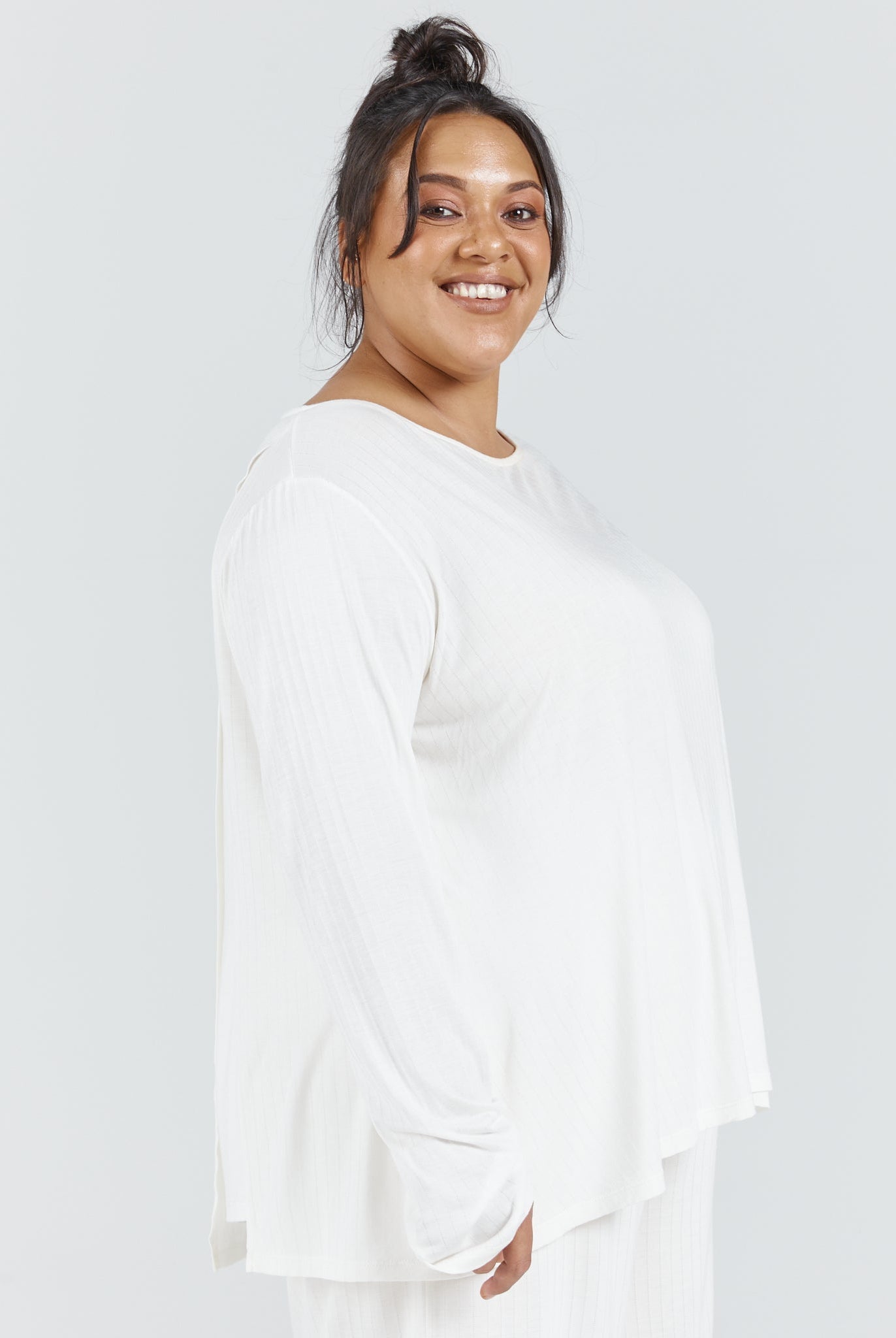 Essensual PJ Top shown in crisp white, featuring a relaxed fit silhouette with long sleeves and round neckline against a light grey background. Part of Christina Stephens sleepwear collection, designed for comfortable nighttime wear.