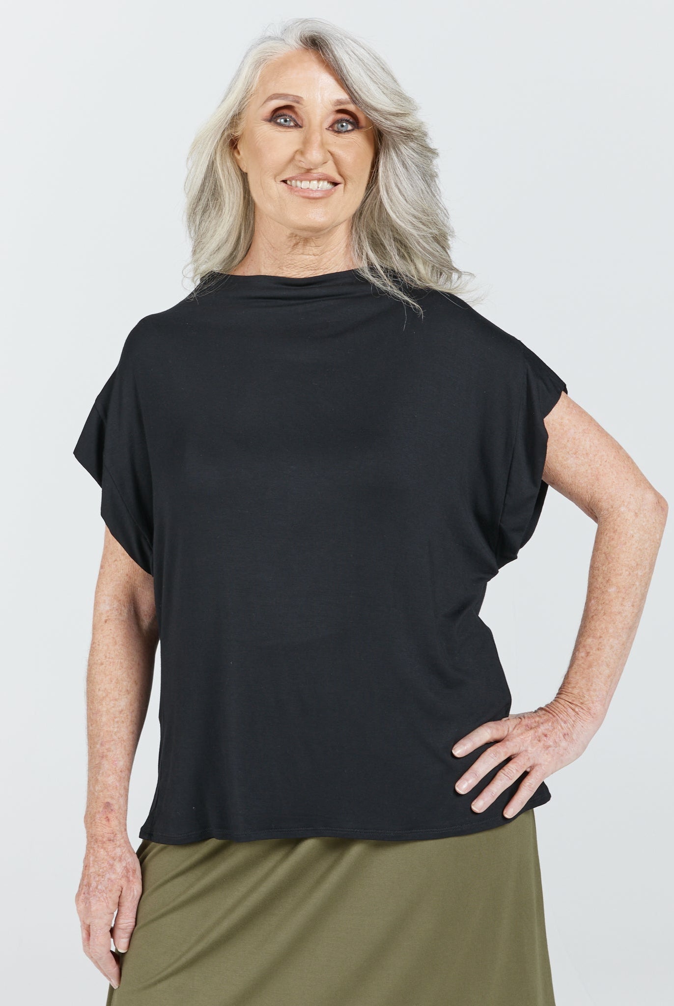 Leaf Back Blouse shown in classic black with relaxed cap sleeves and elegant draping, styled against a light background. The Asian-inspired design features a clean silhouette and minimalist aesthetic, perfect for versatile styling.