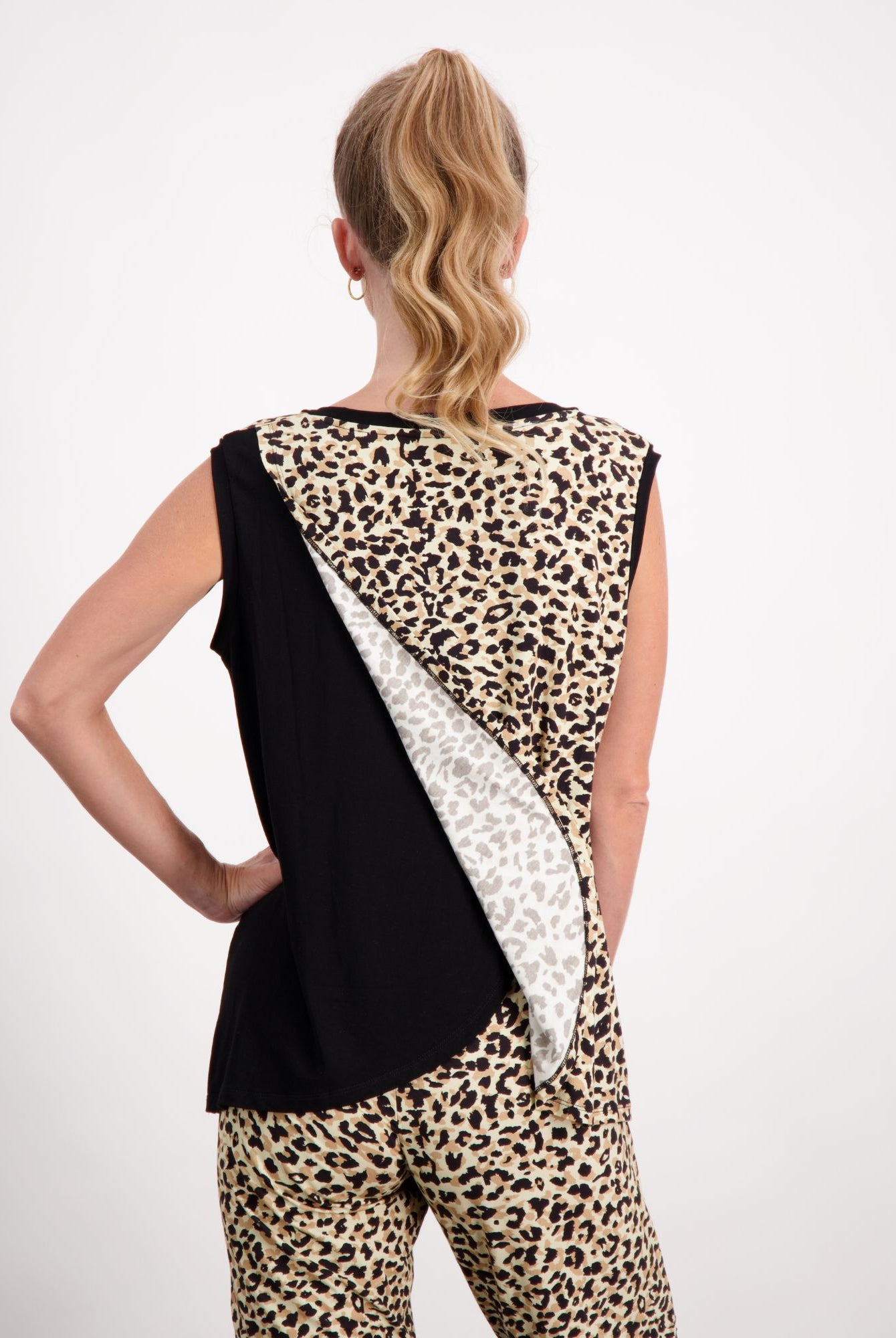 Lauren Sleeveless Physio Top shown from the back, featuring a unique diagonal design with black, white, and leopard print panels. The sleeveless cut showcases the distinctive leaf-inspired pattern across the upper back, perfect for athletic or casual wear.