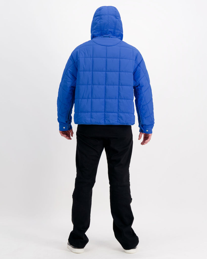Standing male is wearing a cobolt blue puffer jacket over black pants. Christina Stephens Adaptive Clothing Australia.