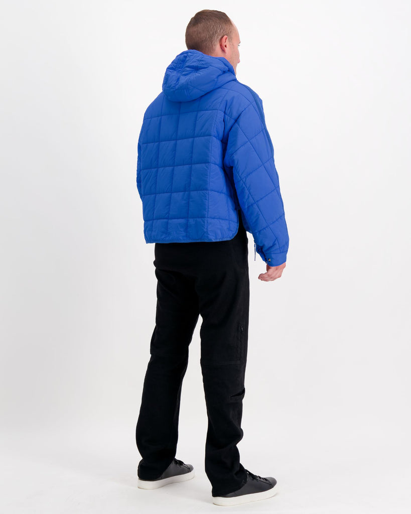 Standing male is wearing a cobolt blue puffer jacket over black pants. Christina Stephens Adaptive Clothing Australia.