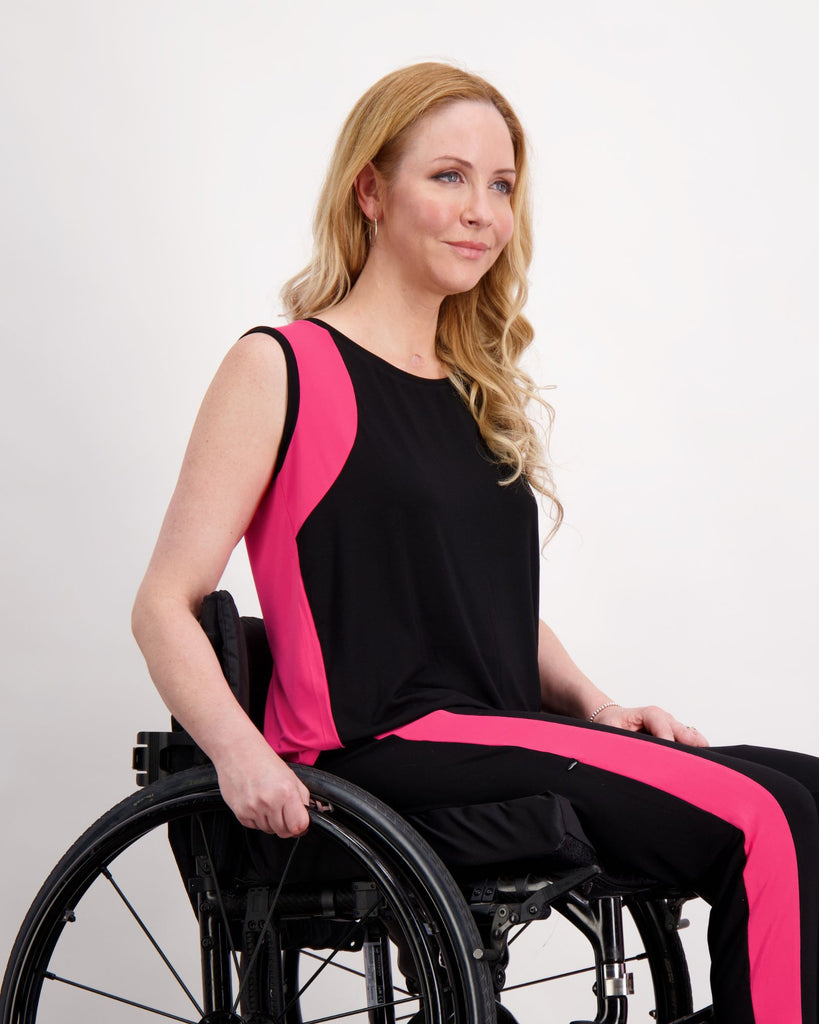 Blonde woman in wheelchair wearing a pink and black physio top and leggings. Christina Stephens Adaptive Clothing Australia. 