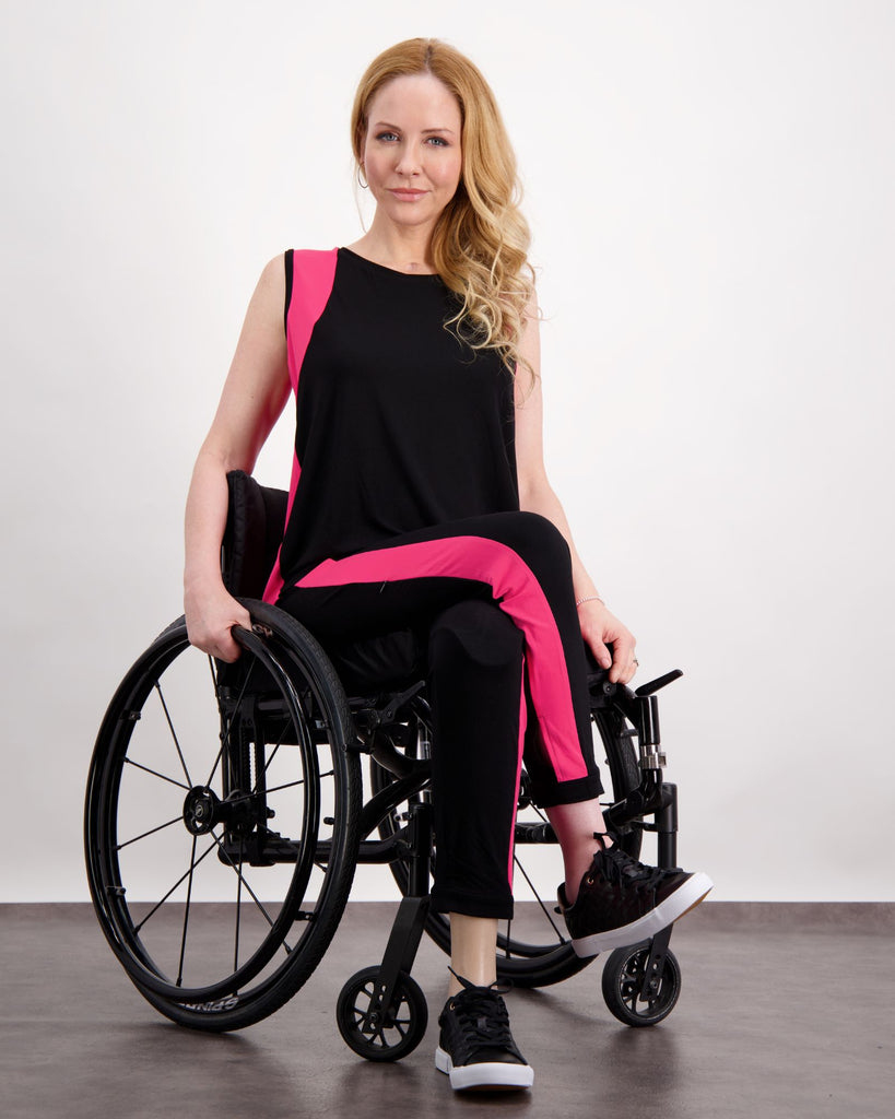 Blonde woman in wheelchair wearing a pink and black physio top and leggings. Christina Stephens Adaptive Clothing Australia. 