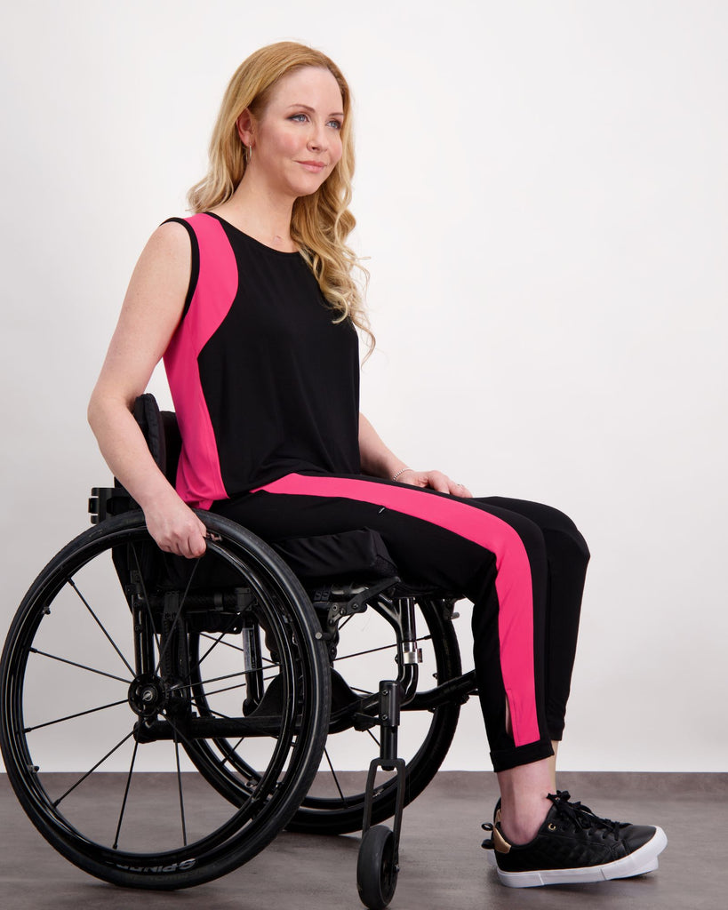 Blonde woman in wheelchair wearing a pink and black physio top and leggings. Christina Stephens Adaptive Clothing Australia. 