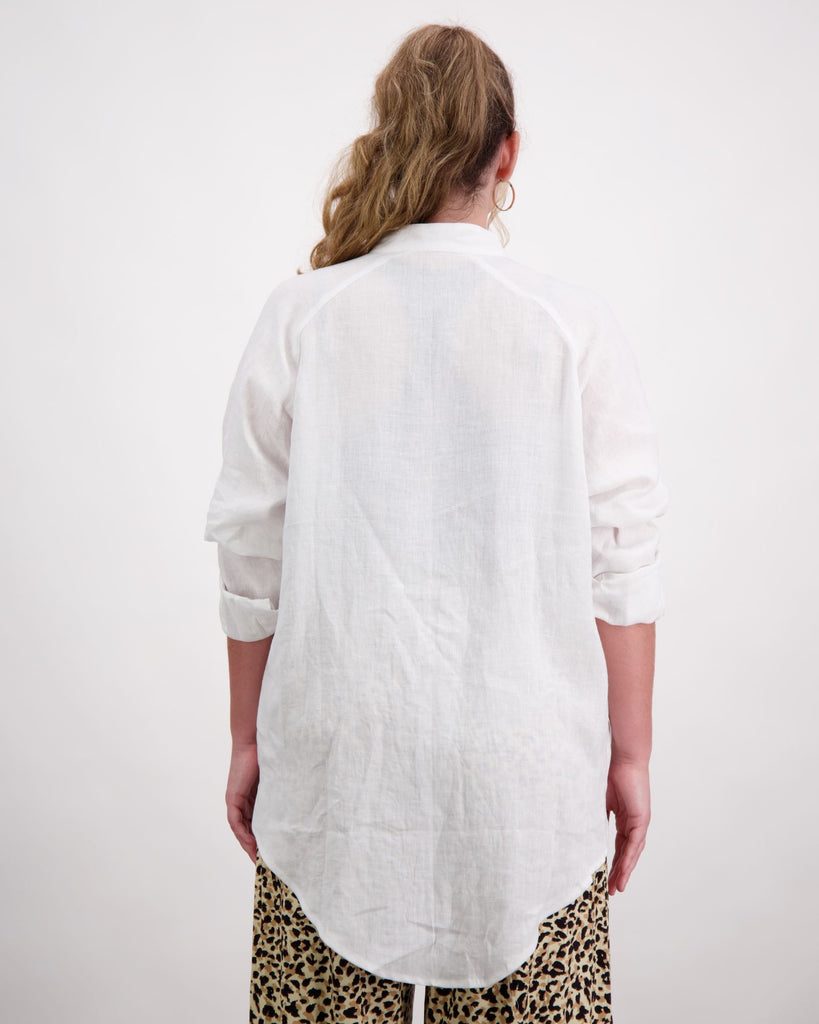 Standing female wearing a grandfather collar white linen shirt. Christina Stephens Adaptive Clothing Australia. 