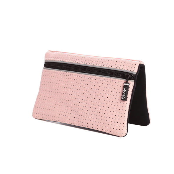 The VIVRA 'Base' waist bag in pastel pink, perforated wallet with a black trim and zipper, adorned with a visible brand tag that says' Vivra', propped up against a white background