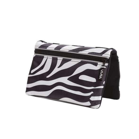 The VIVRA ‘Vivid’ waist bag in a striking black and white abstract zebra stripe pattern, a black zipper, and a brand tag that says, ‘Vivra’, presented against a white backgroun