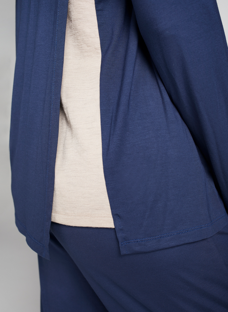 Blue and beige top. Side of garment in focus. Beige merino wool underlay on display.