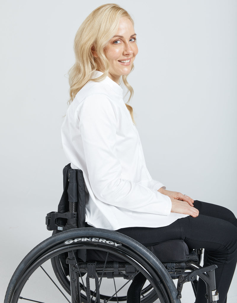 Image of a blonde female in a wheelchair wearing a white Chinese collared shirt with black leggings. Christina Stephens Adaptive Clothing Australia. 