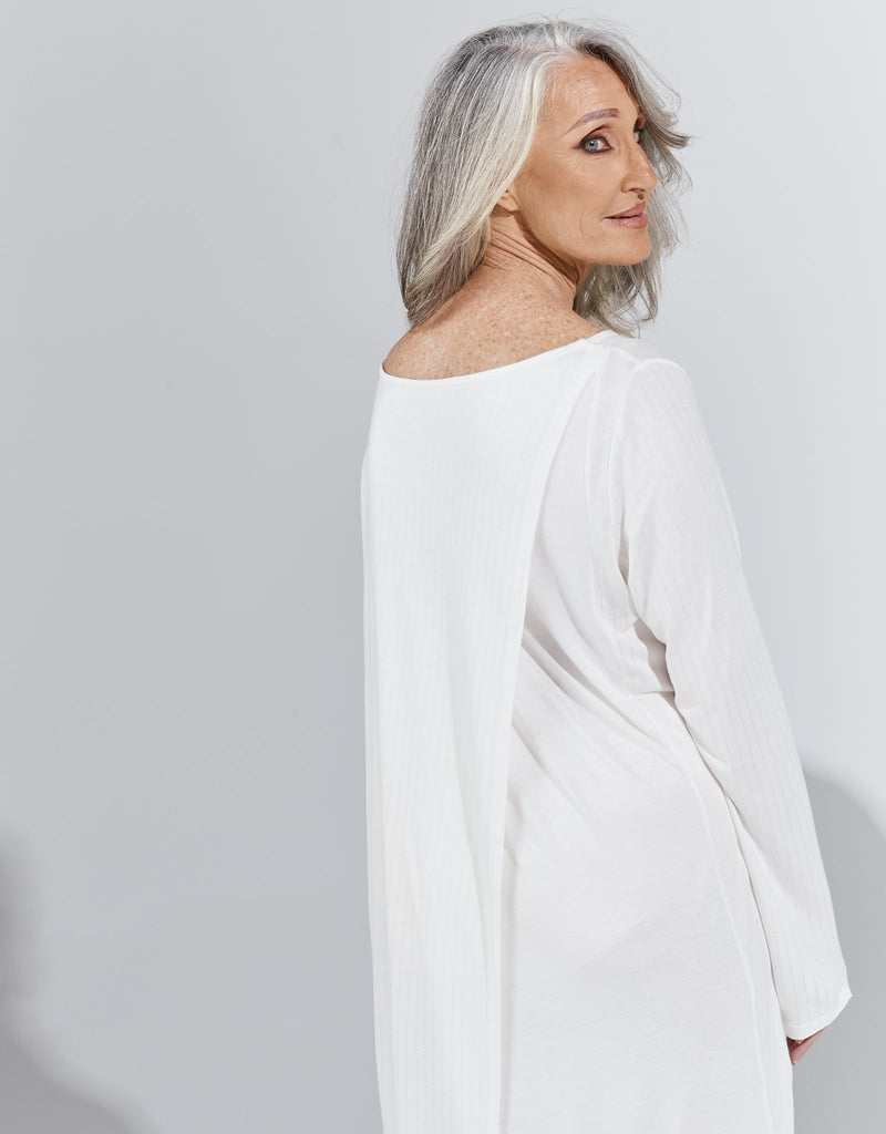 Image of a standing female with grey hair wearing a cream knee length, long sleeved night gown. Christina Stephens Adaptive Clothing Australia. 