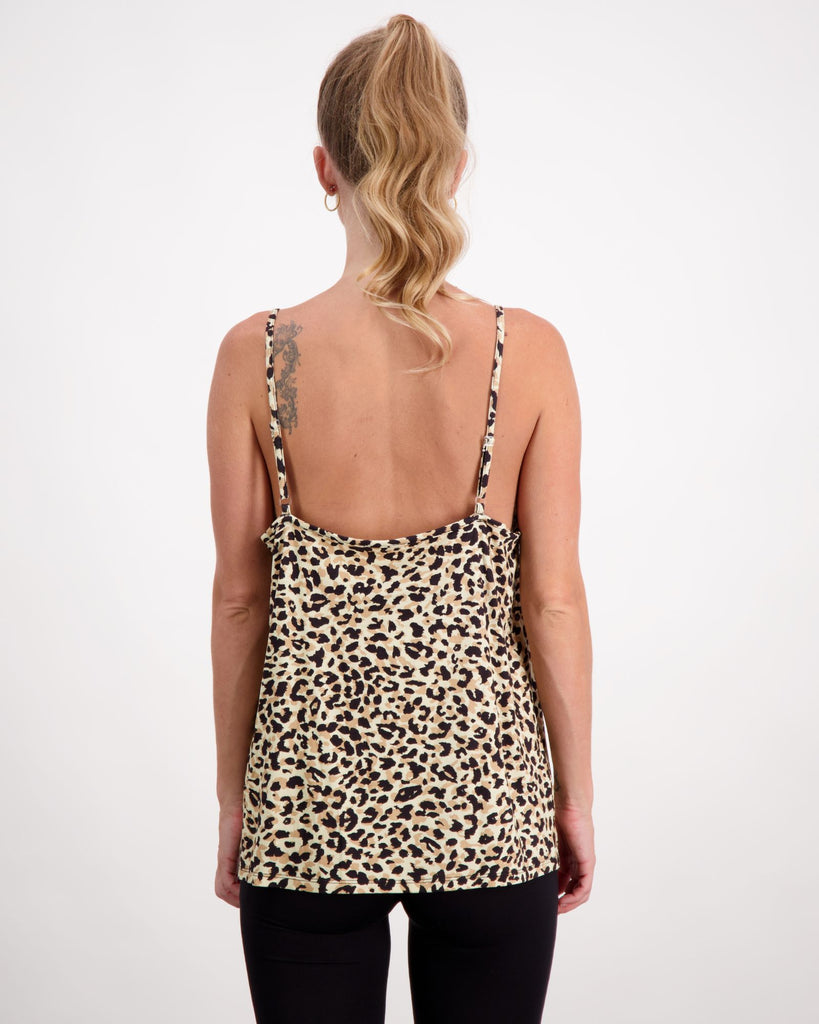 Blonde standing female is wearing leopard print camisole top with gold loop earrings. She is facing backwards. Christina Stephens Australian Adaptive Clothing.  