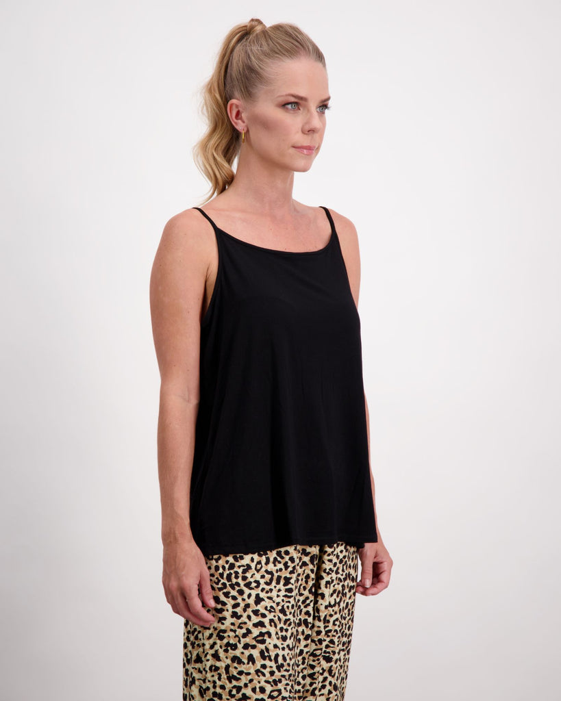 Blonde standing female is wearing a black camisole top with gold loop earrings. She is side facing. Christina Stephens Australian Adaptive Clothing.  